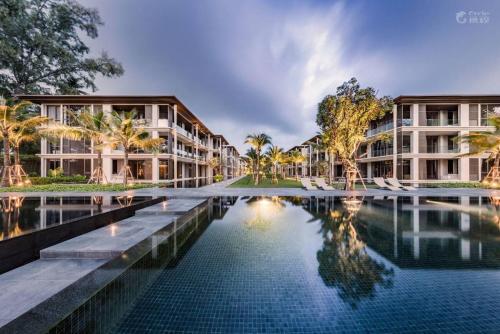 a resort with a pool in front of a building at Baan mai khao apartment in Mai Khao Beach