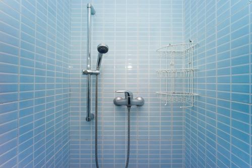 a blue tiled shower with a shower head and a shower at Amplio apartamento con terraza en zona muy tranquila in Barcelona