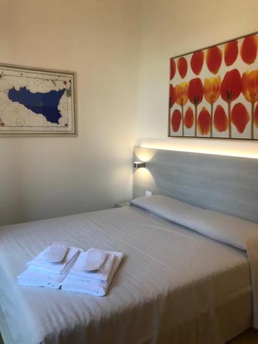 un letto bianco con due asciugamani sopra di B&B Da Bibi a Palermo