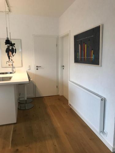 een witte kamer met een aanrecht, een wastafel en een deur bij Ferienwohnung Gierse in Schmallenberg