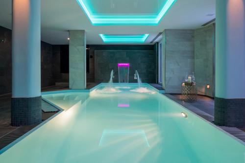 a swimming pool in a building with blue lights at Grand H&ocirc;tel des Alpes in Chamonix-Mont-Blanc