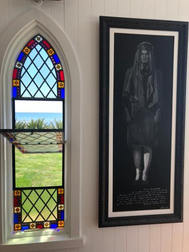 a window and a picture of a statue next to it at Little Church Bay in New Plymouth
