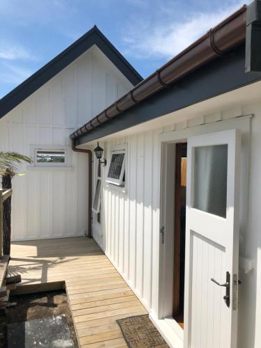a white garage with a door and a porch at Little Church Bay in New Plymouth