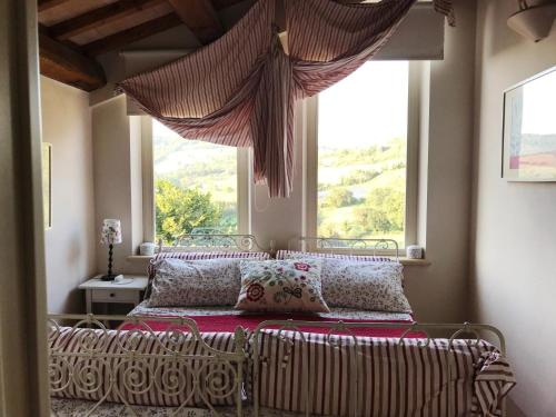uma cama num quarto com uma grande janela em La casa rossa sull'arco romano em Otricoli