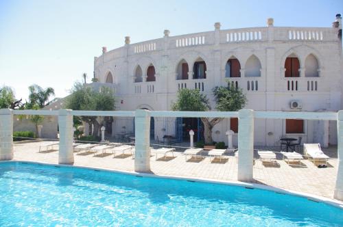 a swimming pool in front of a building at Hotel Nicolaj in Polignano a Mare