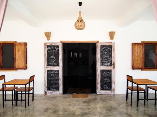 a restaurant with tables and chairs in front of a door at Villa Huruma in Paje