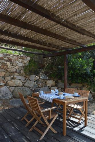 a wooden table and chairs under a wooden pergola at Casa Bithia in Chia