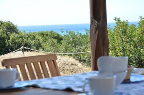 einen Tisch mit Tassen und Untertassen auf einem Tisch mit Aussicht in der Unterkunft Casa Bithia in Chia
