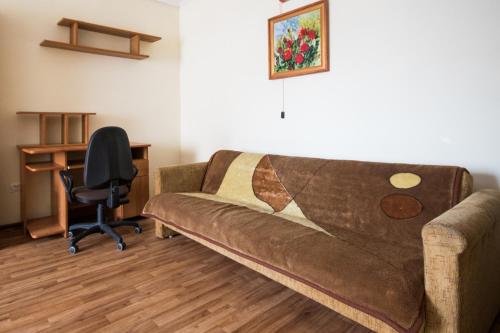een woonkamer met een bruine bank en een bureau bij Apartament z 3 sypialniami na wyłączny użytek - Selekcyjna 15 in Łódź