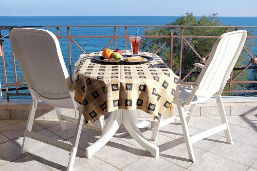 a table with a plate of fruit and a drink at Hotel Pelagos Studios in Platána