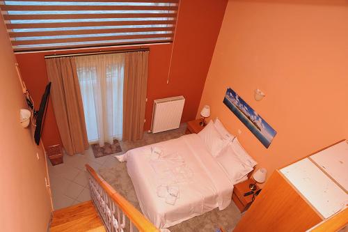 a small bedroom with a bed and a window at Hotel Pelagos Studios in Platána