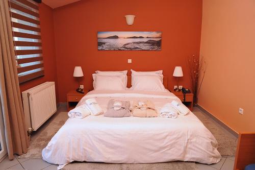 a bedroom with a bed with two dolls on it at Hotel Pelagos Studios in Platána