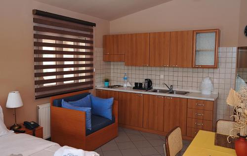 a kitchen with a blue chair and a sink at Hotel Pelagos Studios in Platána