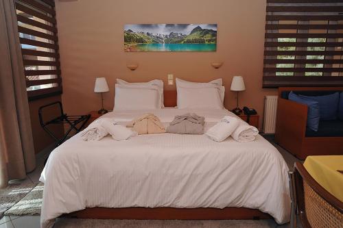 a bedroom with a white bed with towels on it at Hotel Pelagos Studios in Platána