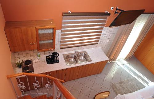 a small kitchen with a sink and a window at Hotel Pelagos Studios in Platána