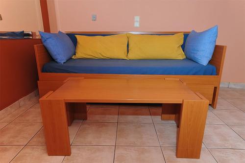 a blue couch with yellow and blue pillows on it at Hotel Pelagos Studios in Platána