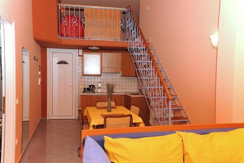 a living room with a staircase and a table and a kitchen at Hotel Pelagos Studios in Platána
