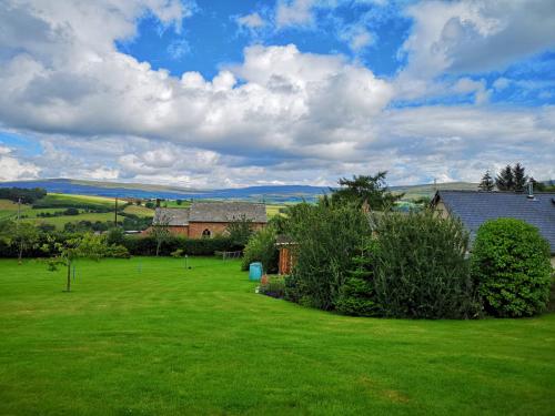 a yard with a house and a green lawn at Summer House, Glassonby in Penrith