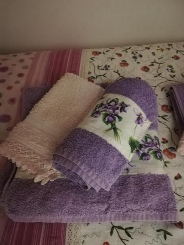 two pillows on a bed with purple blankets at Casetta next to the Creek Dino Buzzati in Belluno