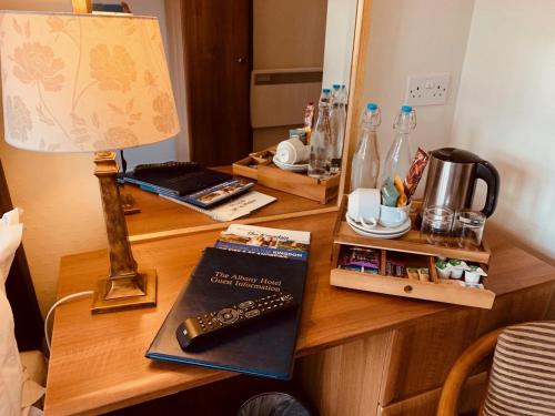 a desk with a lamp and a remote control on it at The Albany St Andrews in St. Andrews