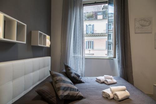 1 dormitorio con ventana y toallas en la cama en Nazionale 221 Luxury Home, en Roma