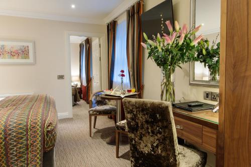 a hotel room with a desk with a vase of flowers at Grand Hotel Tralee in Tralee