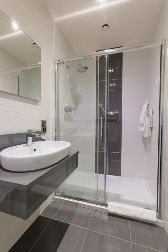 a bathroom with a glass shower and a sink at Grand Hotel Tralee in Tralee