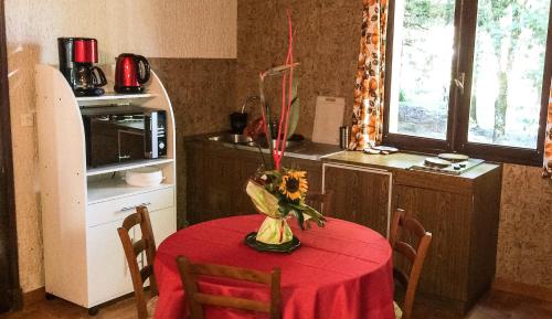 Una cocina con una mesa con un mantel rojo encima. en Studio duplex 1 Lac des Montagnès, en Mazamet