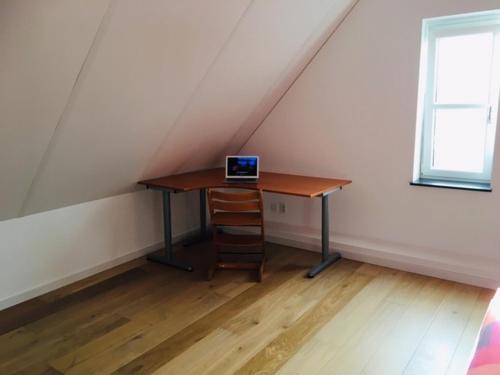 a laptop computer sitting on a desk in a attic at Slaapplaatsen 2-4 personen voor bezoek DTRH in Beuningen