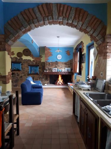 a kitchen with a living room with a fireplace at B&B La Dolce Sosta in Fonni