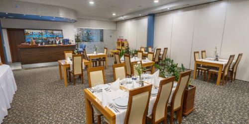 a dining room with tables and chairs and a counter at Hotel Komfort in Krzywaczka