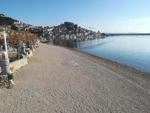 una playa con un cuerpo de agua y algunas casas en Apartment Antonela en Šibenik