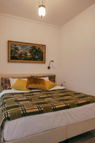 a bedroom with a bed with a picture on the wall at SOEPP hotel & restaurant in Alkmaar