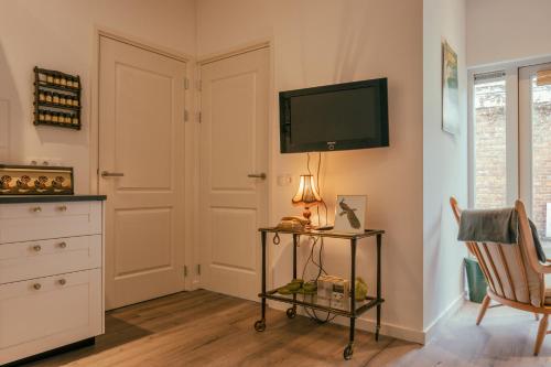 a living room with a television and a chair at SOEPP hotel & restaurant in Alkmaar