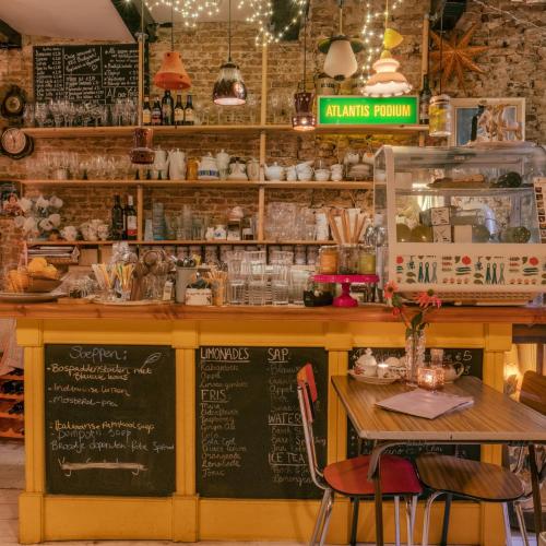 a restaurant with a counter with a table and a chalkboard at SOEPP hotel & restaurant in Alkmaar