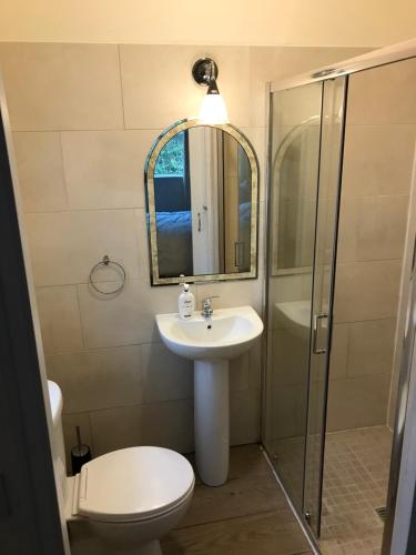 a bathroom with a toilet and a sink and a shower at Teach Fia in Ballina
