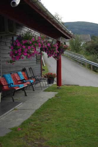 a patio with benches and flowers hanging from a building at Haugo Utleige Lodge in Vossevangen