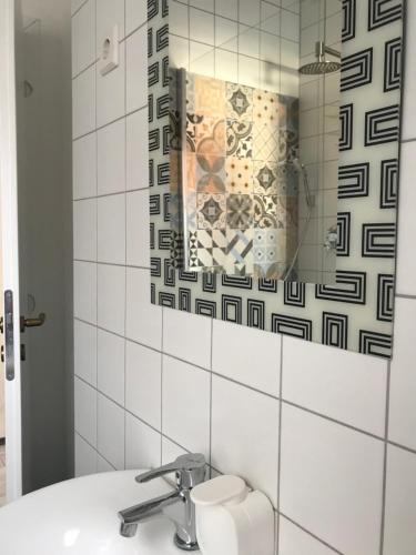 a bathroom with a sink and a mirror at Viktória Inn Tihany in Tihany