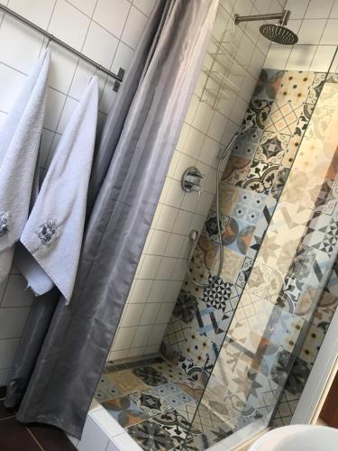 a bathroom with a shower with a shower curtain at Viktória Inn Tihany in Tihany