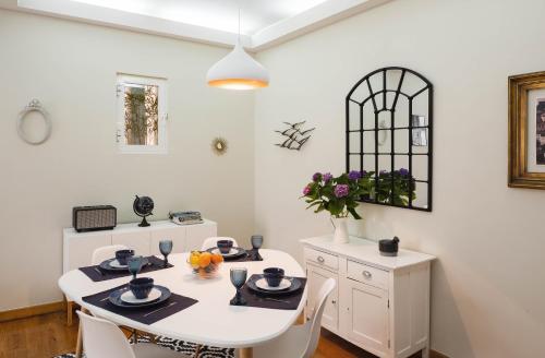a white dining room with a white table and chairs at Alma de Santos Apartment in Lisbon
