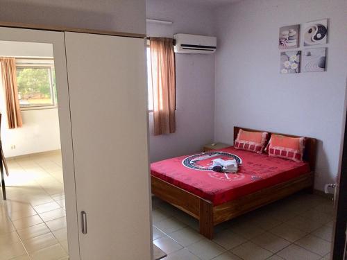 um quarto com uma cama com uma colcha vermelha em Hotel Marie Antoinette Lome em Lomé