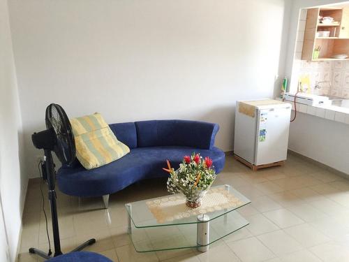 a living room with a blue couch and a table at Hotel Marie Antoinette Lome in Lomé