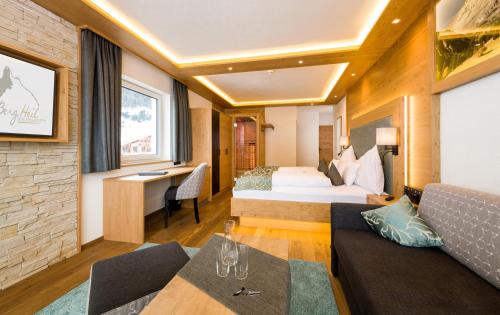 a hotel room with a bed and a couch at Wohlfühlhotel Berg Heil in Holzgau