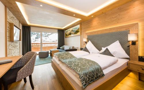 a hotel room with a bed and a desk and a desk at Wohlfühlhotel Berg Heil in Holzgau