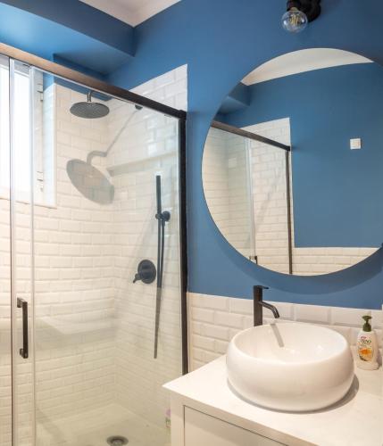 a bathroom with a sink and a glass shower at Alma de Santos Apartment in Lisbon