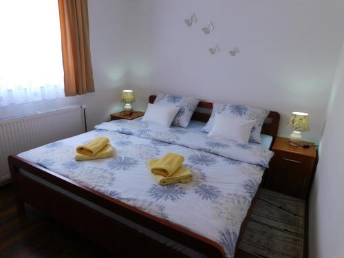 a bedroom with a bed with two yellow towels on it at Apartment Petrovic in Slunj