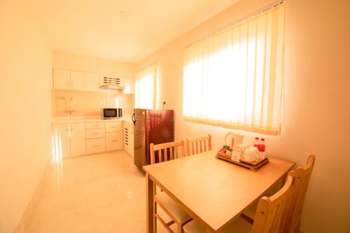 a kitchen with a wooden table and a table and a window at Hotel Harrison Palace in Birātnagar