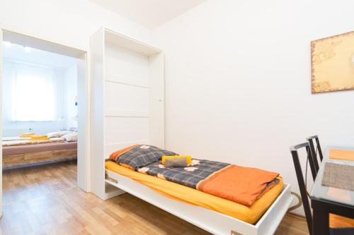 a room with a bed and a desk and a table at Private apartments with direct subway entrance in Fürth