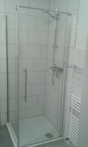 a shower with a glass door in a bathroom at Ferienwohnung Landluft in Ostercappeln