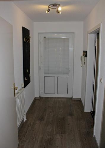 an empty room with a hallway with a door and wood floors at Pura Vida Fehmarn in Fehmarn